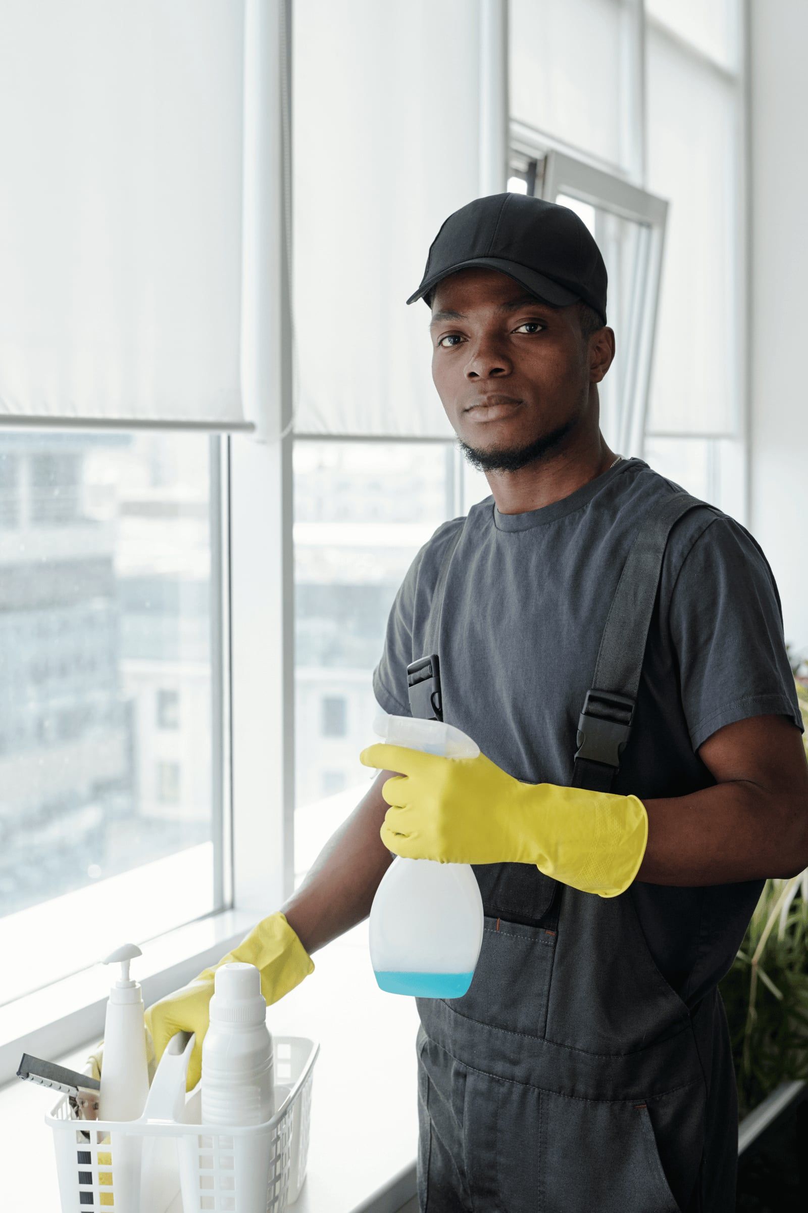 Agent d'entretien nettoyant une vitre dans des bureaux